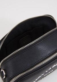 Borsa a tracolla in pelle nera con zip argentata, esterno texture, scomparto principale unico e tasca interna. Logo impresso all'interno.