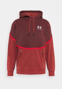 Roter und brauner Hoodie mit strukturierter Oberseite, verstellbarem Kordelzug-Hood, seitlichen Reißverschlusstaschen und gesticktem Logo auf der Brust.