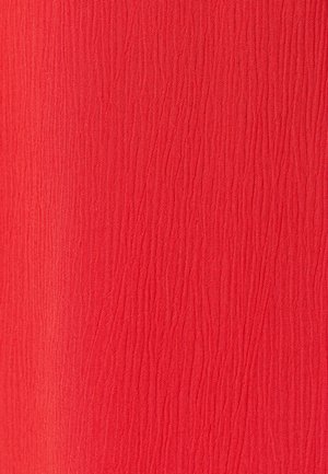 Rode stof met een fijne, verticale gerimpelde textuur en lichte schaduwvariaties over het hele oppervlak.