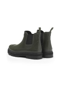 Groene rubberen Chelsea-boots met zwarte elastische zijpanelen, een dikke zwarte zool en treklussen voor gemakkelijk aan- en uittrekken. Gladde textuur en afgeronde vorm.