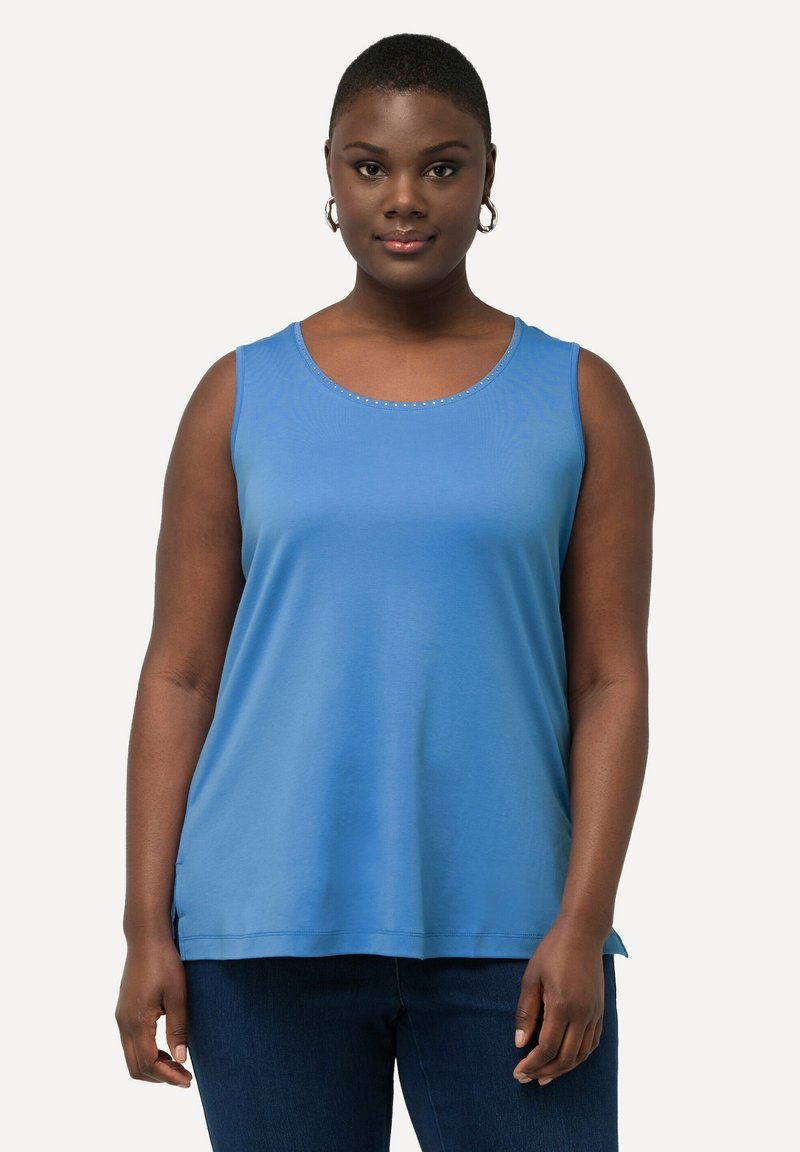 Top senza maniche blu in tessuto morbido con scollatura tonda, caratterizzato da un sottile dettaglio di perline lungo il colletto, abbinato a jeans scuri.