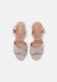 Sandalias de ante beige con la puntera al descubierto, con tiras cruzadas y cierre de hebilla. Acabado suave con una suela plana y sólida. Plantilla con la marca "ANNA FIELD".