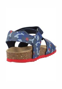 Sandalia de patrón de camuflaje azul con acentos rojos, planta de corcho, correa ajustable y suela de goma texturizada. Diseño abierto para transpirabilidad.