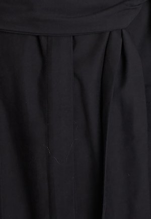 Mustmust kanga, millelõhedega disainiga. Materjal näeb välja sile ja matt, sealhulgas delikaatsed tekstuurimuutused.