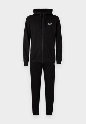 Černá mikina s kapucí na zip a odpovídající tepláky vyrobené z měkké tkaniny. Obsahuje kapuci, elastické manžety a logo "EA7" na hrudi a nohavicích.