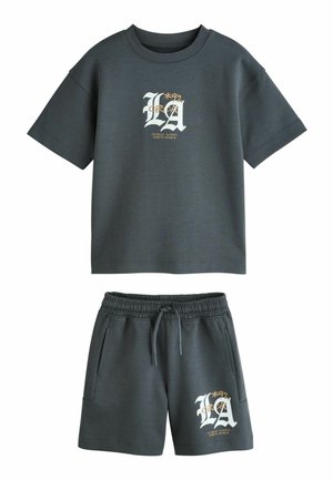 Tamsiai pilkos spalvos trumpomis rankovėmis marškinėlių ir šortų komplektas su elastinga liemene, kišenėmis ir baltai geltonu užrašu „LA 1992 Los Angeles California“.