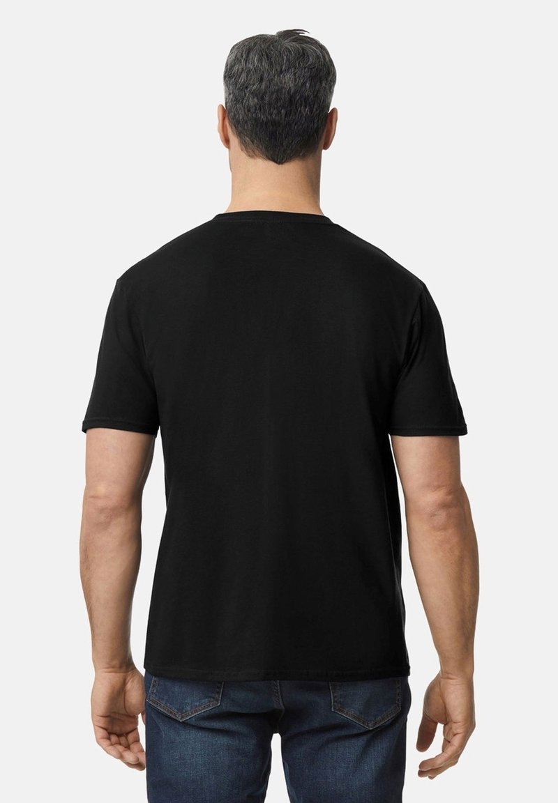 Camiseta negra de manga corta con un clásico cuello redondo, fabricada en suave algodón y con un diseño liso en la parte posterior, combinada con vaqueros azules.