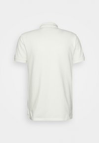 Kortärmad pikétröja i off-white bomull, med en klassisk krage och rak nederkant. Slät textur utan synliga mönster eller detaljer.