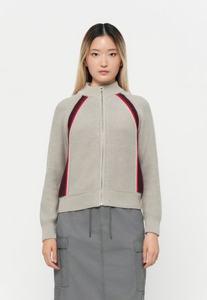 Maglione grigio chiaro a maglia, con zip, e accenti laterali in bordeaux e rosso. Presenta un colletto alto e polsini a costine. Design casual con vestibilità comoda.