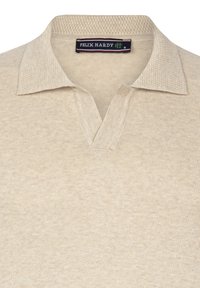 Lichtbeige polo shirt met een gestructureerde gebreide kraag, v-halsontwerp en subtiel tonale patroon. Merklabel "FELIX HARDY" zichtbaar aan de binnenkant van de kraag.