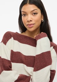 Sweater listrado em bordeaux e creme, malha de textura suave, decote amplo, ajuste ligeiramente oversized, com punhos e barra canelados.