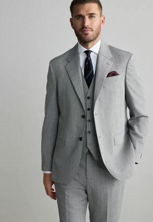 Gray three-piece suit featuring a textured fabric, notch lapels, and a pocket square. White shirt and dark tie complete the ensemble.