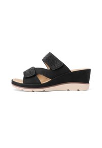 Sandali con zeppa nera e due cinturini regolabili in velcro. Materiale in suede liscio, texture sottile e suola in gomma chiara.