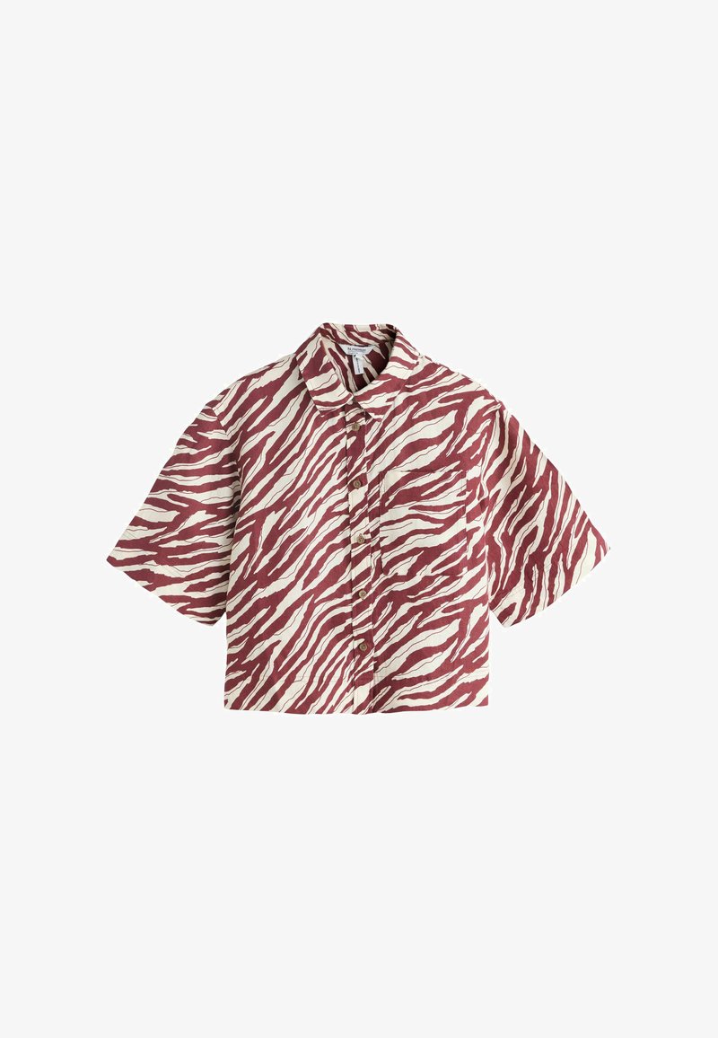 Chemise à manches courtes boutonnée avec des rayures zébrées rouges et blanches et une poche poitrine gauche, posée à plat sur un fond blanc.