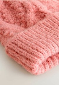 Miękki, puszysty różowy sweter z dżerseju z wełny z pr�ążkowanymi mankietami i teksturowanymi wzorami, złożony na białej powierzchni.