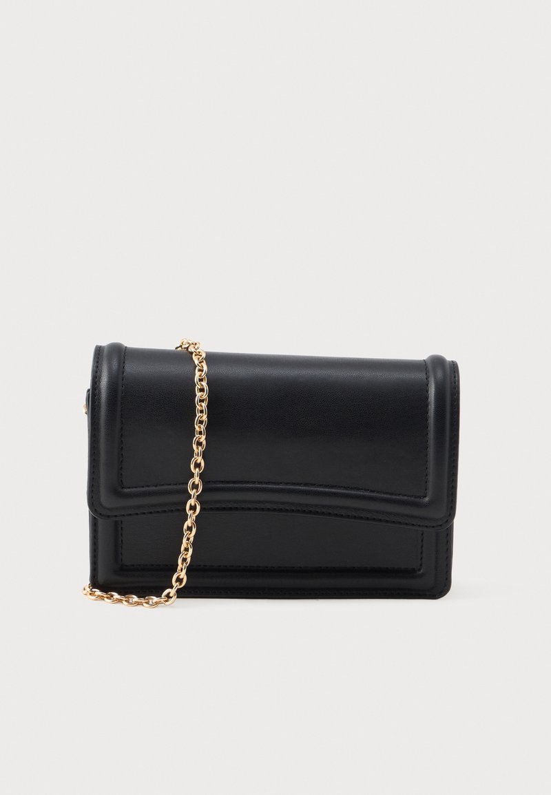 Pochette rectangulaire en cuir noir avec un rabat avant et une bandoulière chaîne dorée sur un fond clair uni.