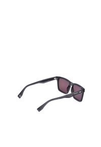 Lunettes de soleil rectangulaires noires avec verres teintés foncés et marquage "Police" sur les branches, présentées de profil sur fond blanc.