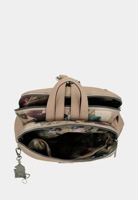 Zaino beige con tre scomparti con cerniera aperta che mostrano un rivestimento di tessuto a fantasia colorata e tasche interne, con un portachiavi in metallo attaccato.