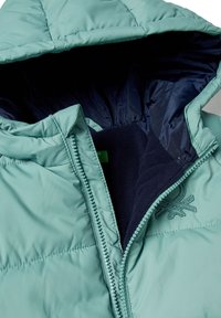 Kurtka puchowa z kapturem w jasnym odcieniu morskim. Posiada zapięcie na zamek oraz granatową podszewkę o miękkiej fakturze, a także ozdobne przeszywane logo.