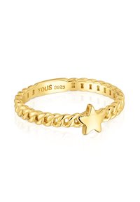 Anello in oro con fascia contorta, decorato da una lucente stella a cinque punte e inciso "TOUS S925" all'interno della fascia.