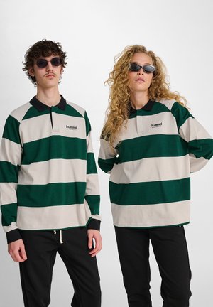Groene en beige gestreepte polo-shirts met lange mouwen en een zwarte kraag. Twee modellen dragen donkere broeken en zonnebrillen. Logo op de borst.