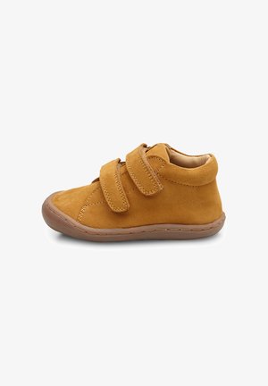 Scarpa per bambini in suede color sabbia con due strap in velcro, punta arrotondata e suola in gomma flessibile. Presenta dettagli cuciti lungo i bordi.