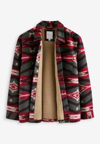 Veste en flanelle carreaux rouge, gris et crème, avec une doublure en sherpa, un col et une fermeture à boutons. Les motifs incluent des formes géométriques et des flèches.