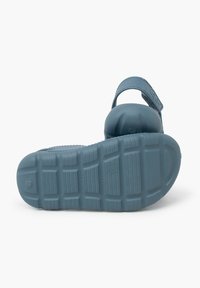 Infradito in gomma blu con retro chiuso, logo impresso, suola texturizzata e cinturino posteriore regolabile. Progettato per offrire comfort e stabilità.