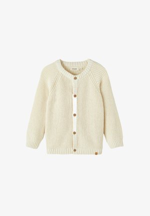 Kreimas adīts džemperis ar apaļu kaklu, raglanu piedurknēm, koka pogām un ribotiem piedurkņu galiem. Vienkārša tekstūra un tīrs dizains.