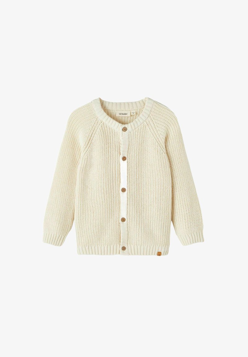 Kreminė megzta kardiganas su apvaliu kaklu, raglanų rankovėmis, mediniais mygtukais ir gumuluotais rankogaliais. Paprasta tekstūra ir švarus dizainas.