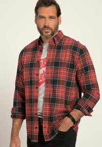 Rot-schwarz karierte Langarmbluse mit Button-Down-Kragen, kombiniert mit einem grauen T-Shirt mit rotem Text, getragen zu schwarzen Hosen.