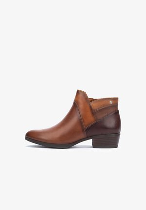 Bottine en cuir marron avec un bout légèrement pointu, un talon en marron foncé contrastant, des coutures latérales et un accent métallique décoratif.