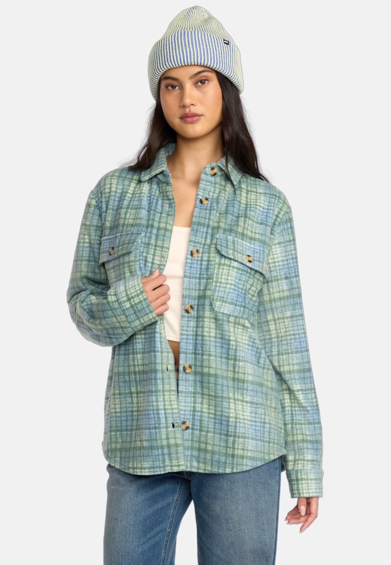 Grøn og blå ternet flannel skjorte med to brystlommer, knapfront og let oversized pasform, parret med en stribet strikket hue.