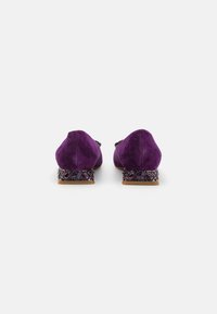 Ballerines en daim violet avec un petit talon à motifs, ornées d'accents semblables à des gemmes. Bout arrondi et texture lisse, conçues pour le confort.