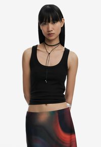 Black ribbed tank top with wide neckline, paired with a multicolored, abstract-patterned skirt. Accessories include a black choker.