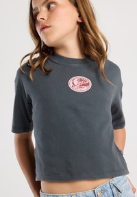 Gray cotton t-shirt with a round neckline, short sleeves, and a pink circular graphic patch on the chest; casual fit and soft texture.