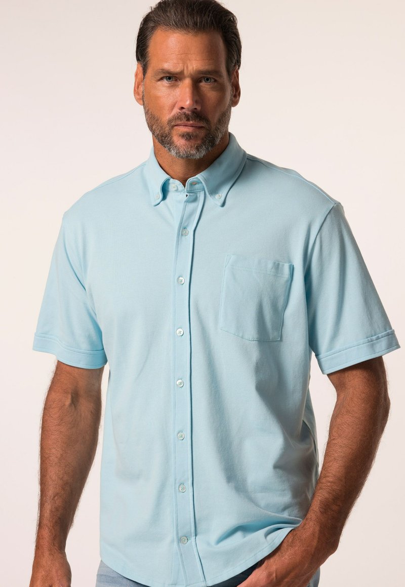Lichtblauw kortslip coll shirt gemaakt van zachte stof, met een knoopsluiting aan de voorkant en een opgestikte zak op de linkerkant van de borst.