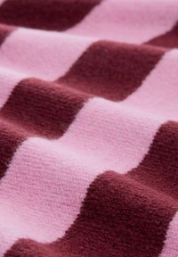 Fleece-Decke mit abwechselnden breiten Streifen in dunklem Burgunderrot und hellem Rosa. Die Textur wirkt weich, mit einem plüschigen Finish.