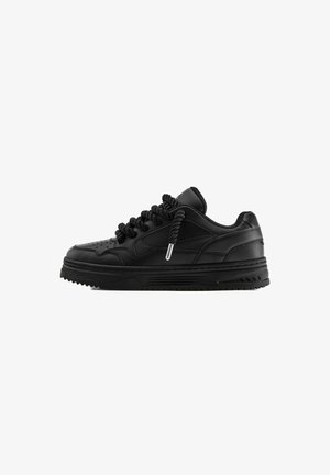 Czarny skórzany niski sneaker z grubą podeszwą, perforowanym noskiem i grubymi skręconymi sznurowadłami, pokazany z profilu na białym tle.