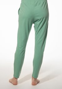 Groene katoenbroek met een ontspannen pasvorm, voorzien van een gladde textuur, taps toelopende benen en een elastische tailleband. Geen zichtbare hardware of patronen.