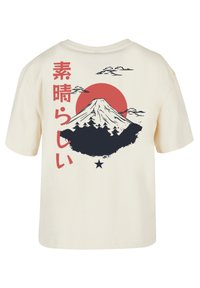 Cremweiße Baumwoll-T-Shirt mit einem Grafikdesign des Mount Fuji, einer roten Sonne, Wolken und rotem japanischen Text, mit einem Sternakzent unterhalb des Designs.