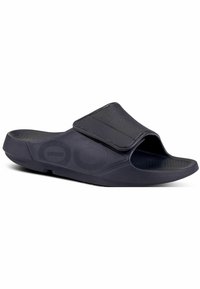 Infradito neri in gomma con una fascetta e una soletta testurizzata. Presentano un design con punta aperta e una suola sagomata per il comfort.