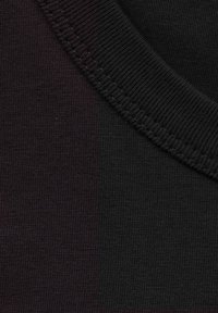 Black cotton fabric with a smooth texture, featuring a crew neckline and ribbed trim. The color appears consistent with subtle shading.