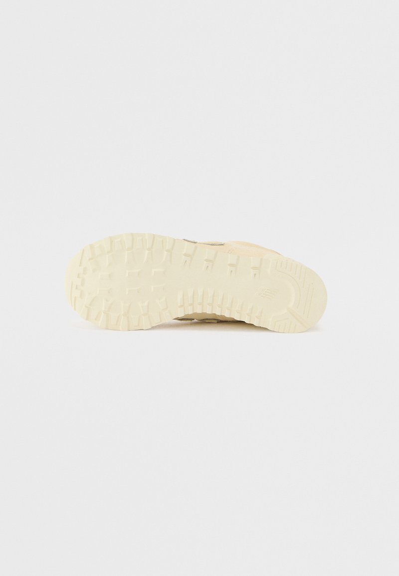 Suela de zapato que presenta un material de goma beige texturizado con un patrón de tracción robusto, diseñado para proporcionar agarre y durabilidad.