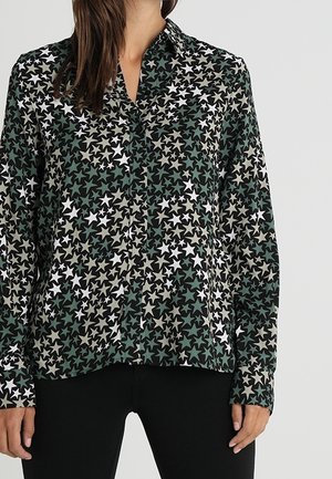 Camicia con maniche lunghe e bottoni in tessuto verde scuro, caratterizzata da un motivo a stelle in bianco, beige e tonalità di verde più chiaro. Design con colletto classico.