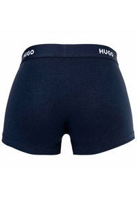 Marineblaue Boxershorts aus glattem Stoff, mit einem weichen elastischen Bund, der das "HUGO"-Logo in Weiß trägt. Einfaches, nahtloses Design.