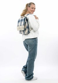 Rucksack mit einem blau-weißen Batikmuster, ausgestattet mit einer strukturierten Oberfläche und cremefarbenen Fransenakzenten. Verstellbare Träger und rechteckige Form.