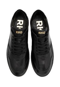 Baskets en cuir noir à finition lisse, avec des lacets noirs, un bout arrondi et un logo "RKO" doré sur la languette.