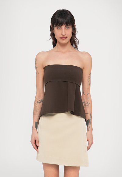 Haut marron bustier avec un design à couches, associé à une jupe beige clair jusqu'aux genoux. Texture lisse, style minimaliste, sans motifs visibles.