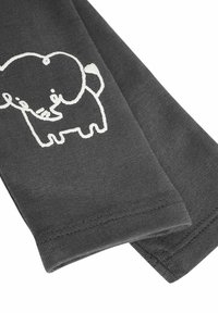 Grijs stof met een gladde textuur heeft een witte omtrek van een olifant. Het ontwerp is eenvoudig en bevindt zich aan één kant van het materiaal.